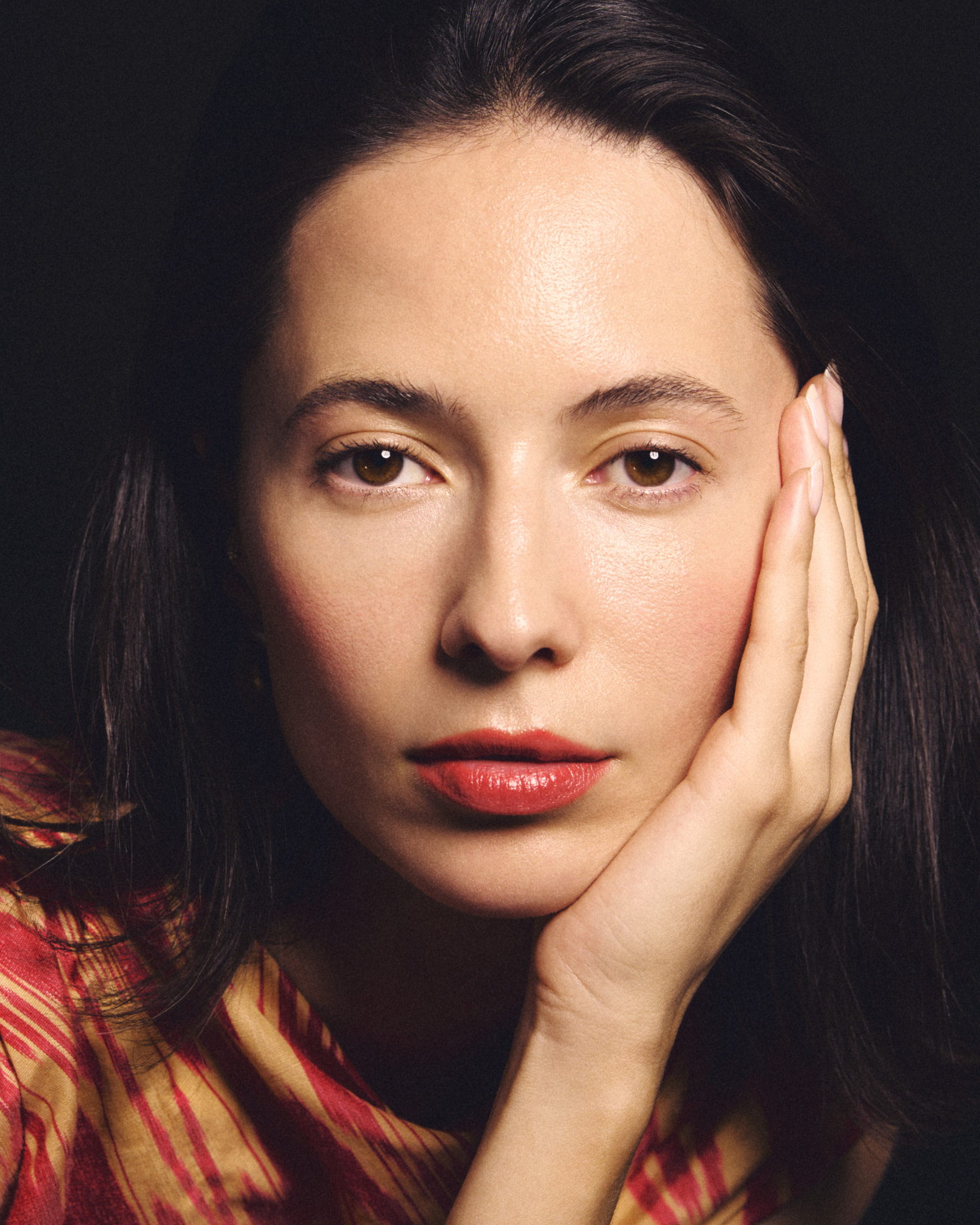 Beauty portrait of a woman resting her hand against her cheek