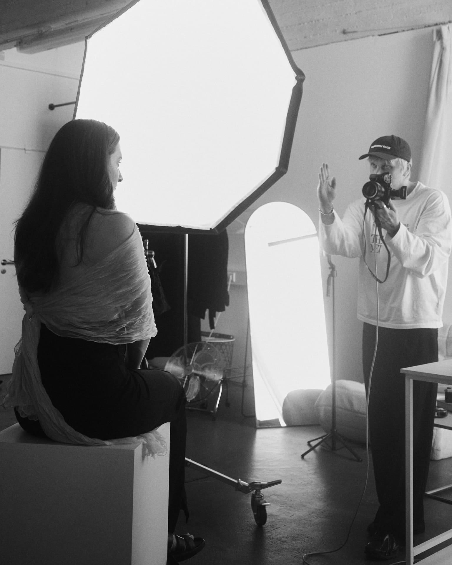 Dmytro Huk directing a model in the studio, camera in hand